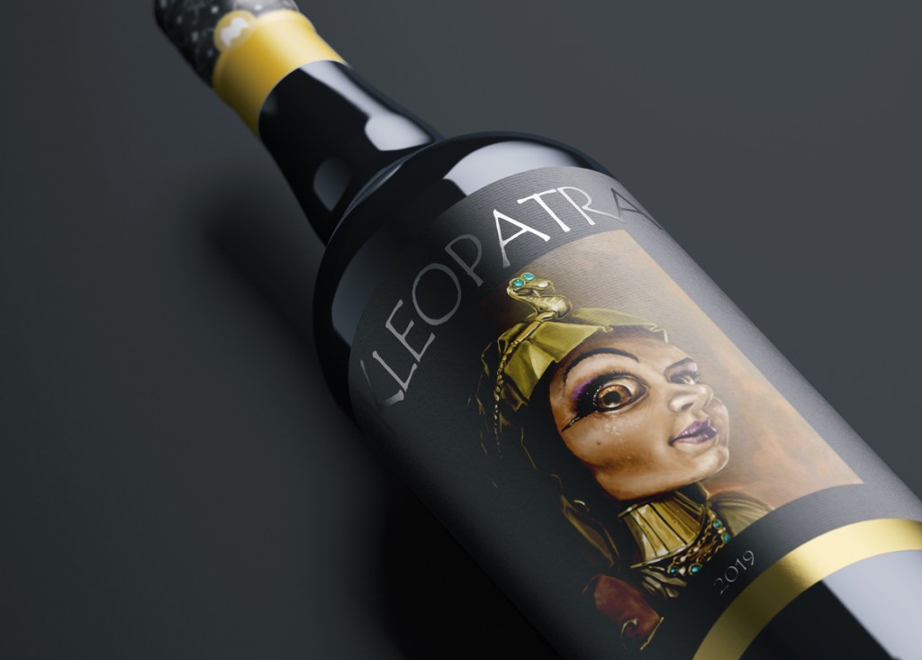 Kuva, jossa mallinnettu viinipullo, etiketissä kuvitus Kleopatrasta.